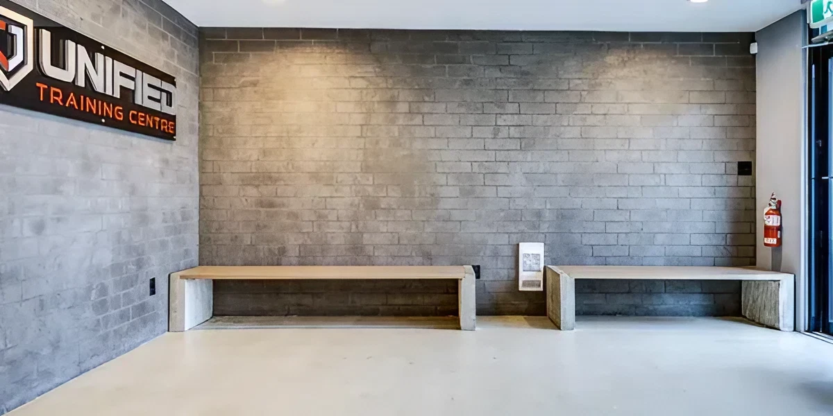 A room with two benches and a brick wall