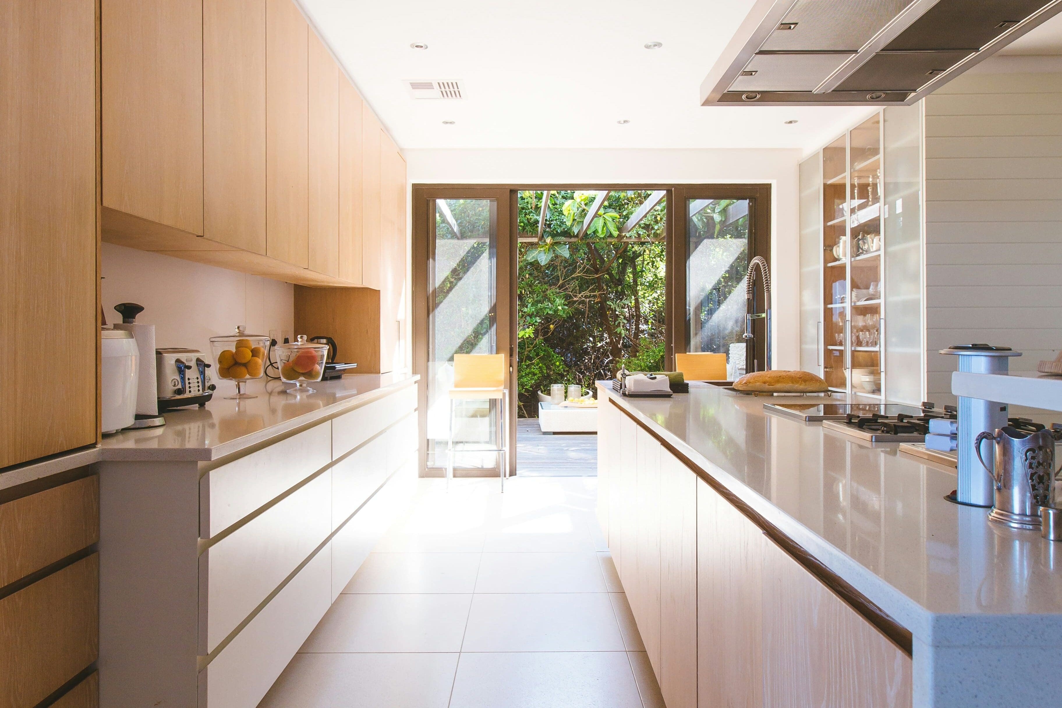 A kitchen with white cabinets and tile floors.