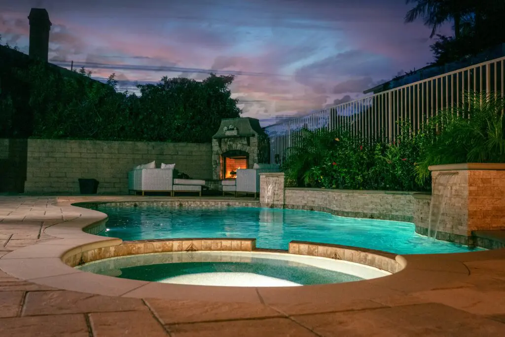 A pool with a fire place and a large swimming pool.