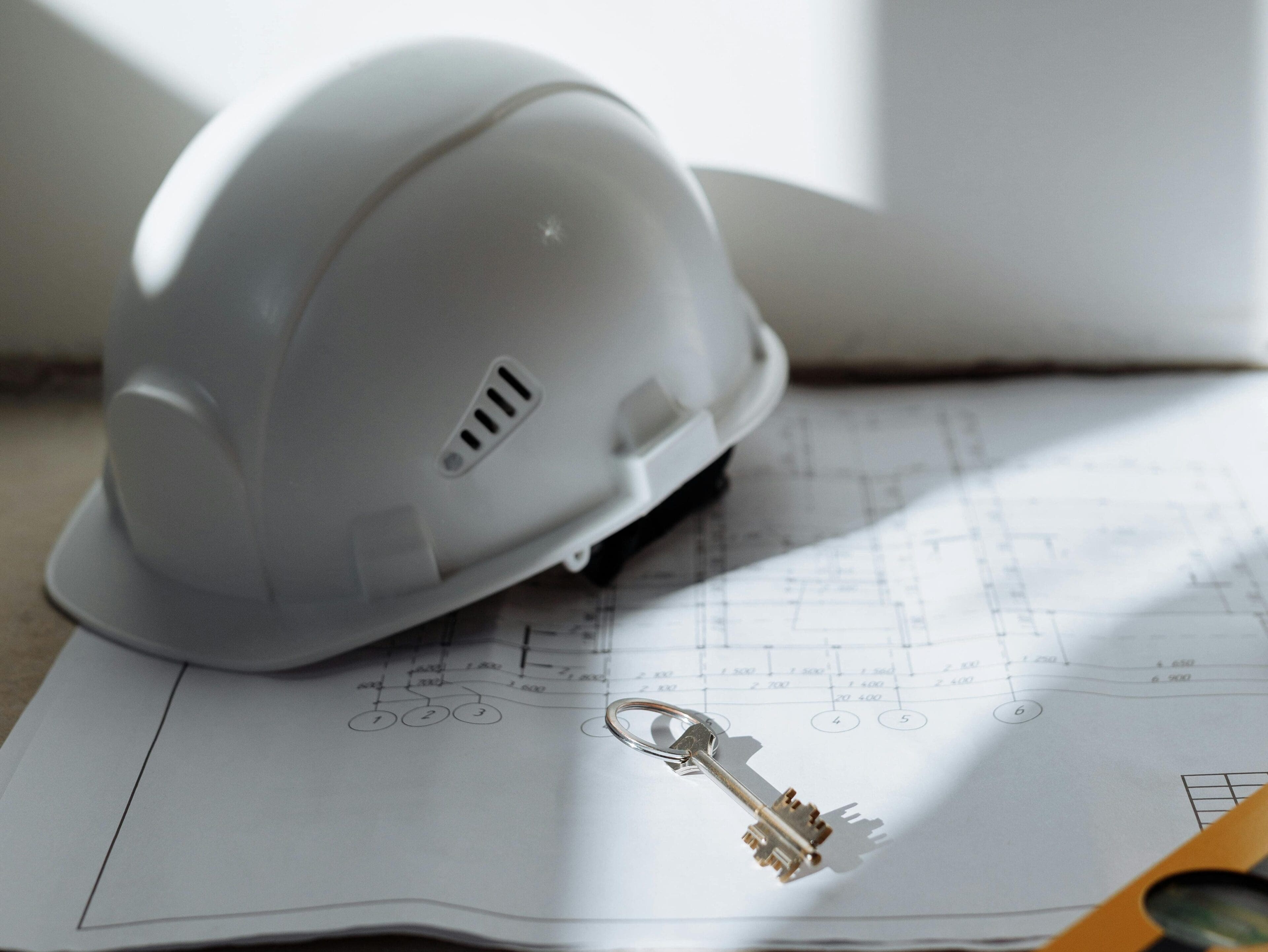 A white hard hat sitting on top of some paper.