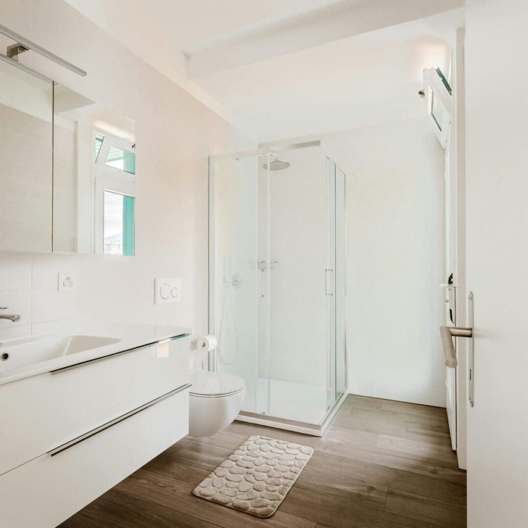 Bright minimal white bathroom with wood floor